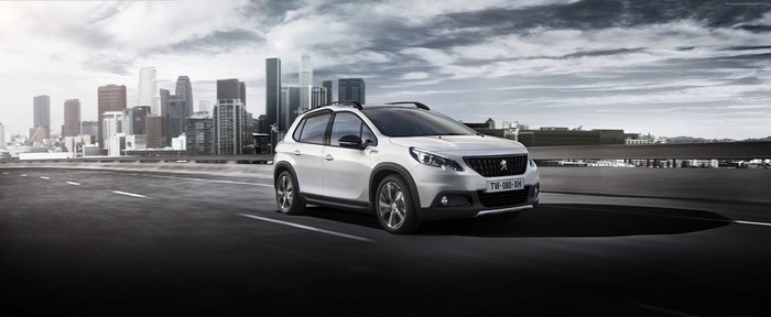 White Peugeot 2008 GT Line crossover driving in city