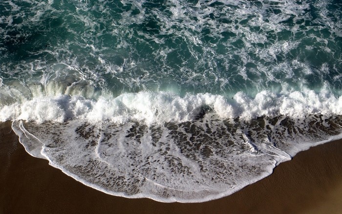 Ocean waves crashing on a sandy beach