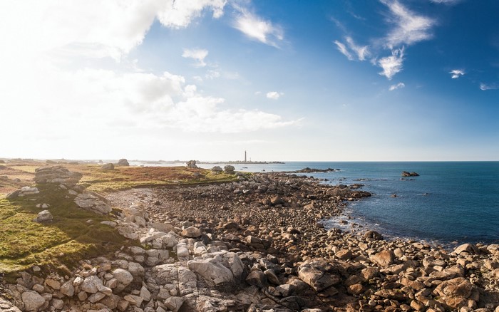Rocky coast with lighthouse and blue sky