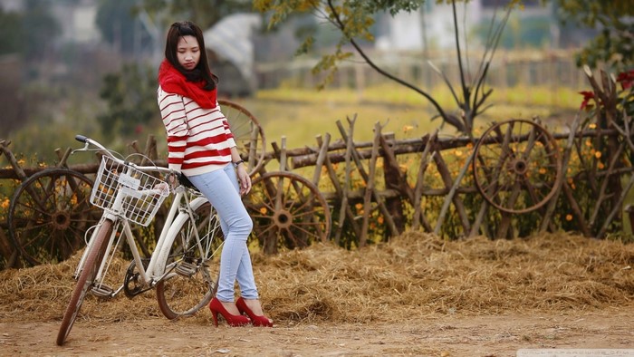 Woman in red scarf and striped sweater with bicycle