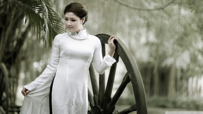 Woman in white dress posing by a cartwheel