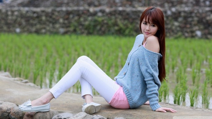 Asian woman sitting in a field