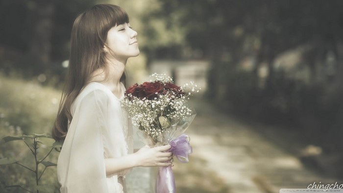 Young Asian woman holding a bouquet of red roses