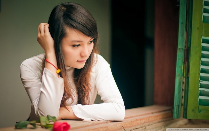 Young Asian woman in white shirt with red rose