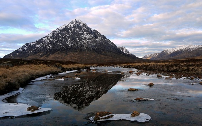 Snow-capped mountain reflected in a frozen river
