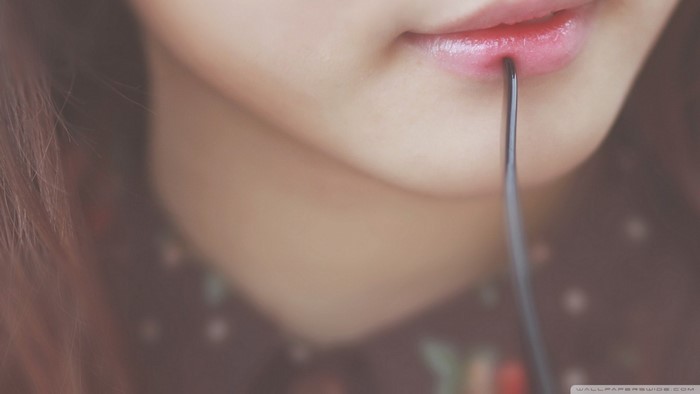 Close up of a woman's lips with a metal object