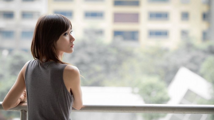 Woman leaning on a railing looking out