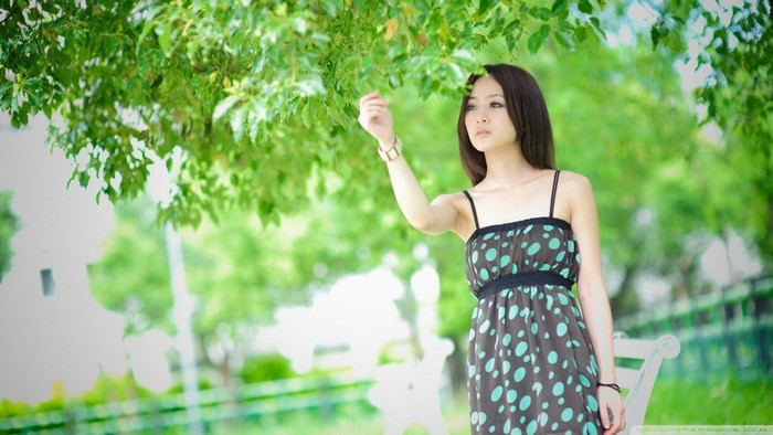 Woman in polka dot dress touching leaves