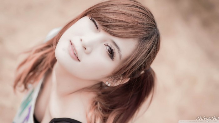 Close-up portrait of a young Asian woman with auburn hair