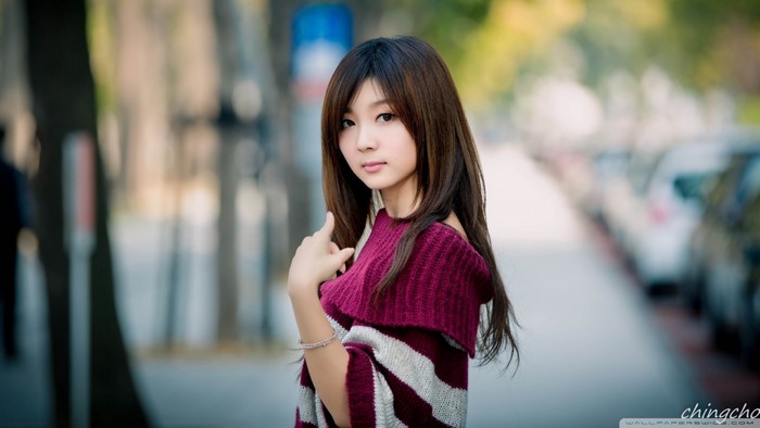 Asian woman with long brown hair wearing a maroon and white sweater