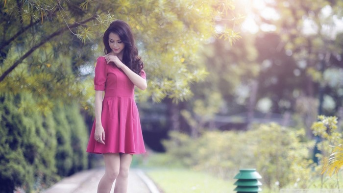 Woman in pink dress in a park