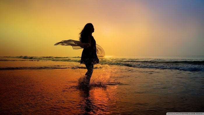 Silhouette of a woman on a beach at sunset