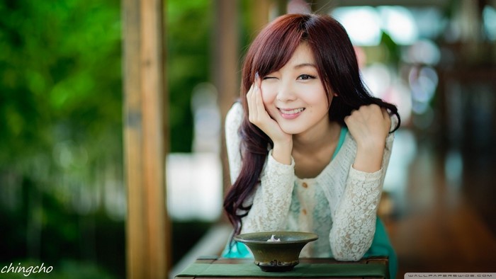 Asian woman with brown hair winking and smiling