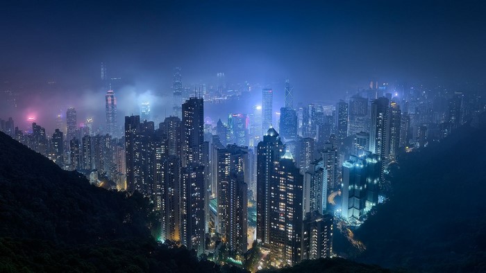 Hong Kong cityscape at night with skyscrapers and fog