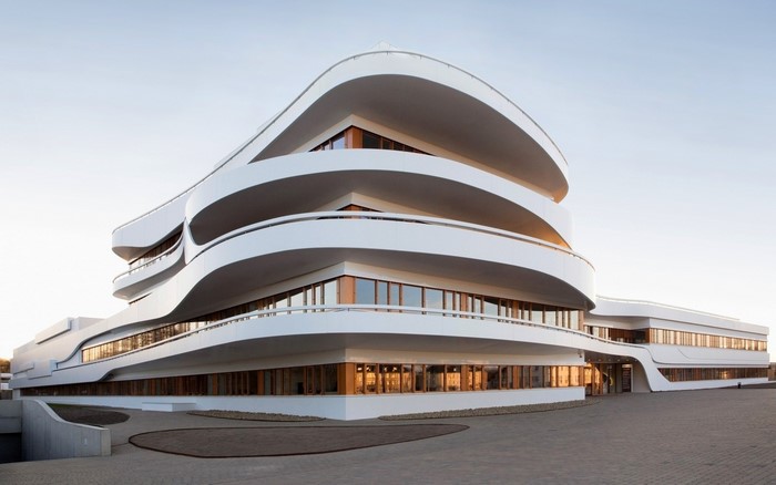 Modern white building with curved balconies and large windows