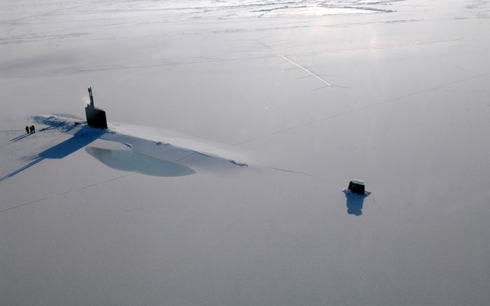 Submarine surfaced in Arctic ice with small structure nearby