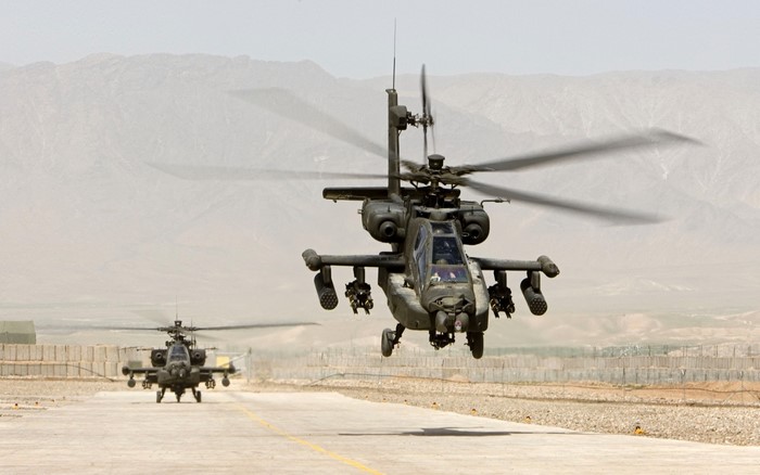 Two Boeing AH-64 Apache helicopters on a runway