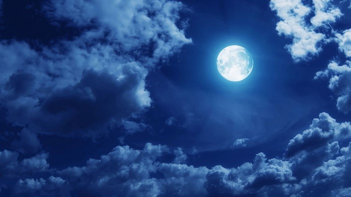 Full moon in a cloudy night sky