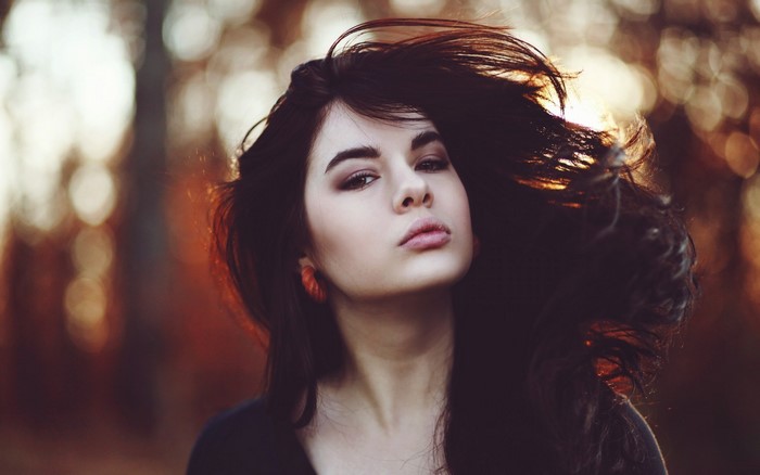 Woman with dark hair blowing in the wind