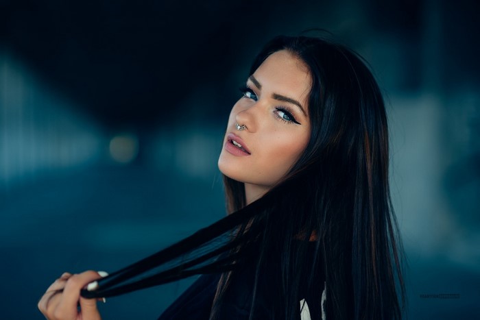 Woman with black hair and nose ring posing