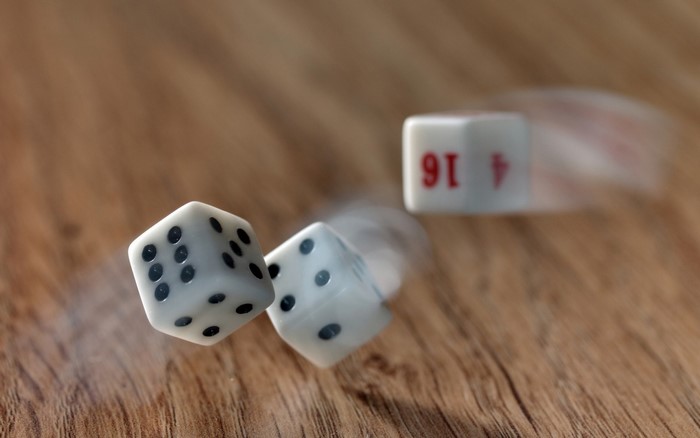 Dice rolling on a wooden surface
