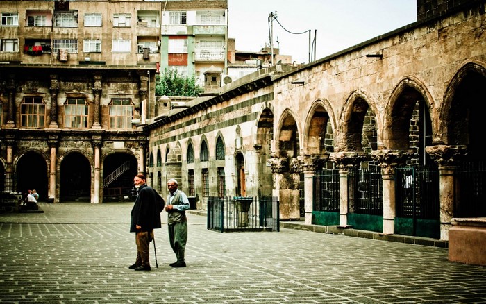 Two men in a courtyard with ancient architecture in Diyarbakir, Turkey