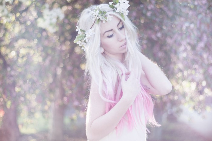 Woman with flower crown and pink hair outdoors