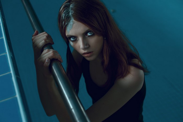 Woman with blue face paint holding a railing