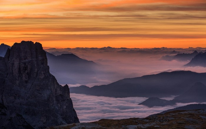 Mountain range at sunset with clouds and mist