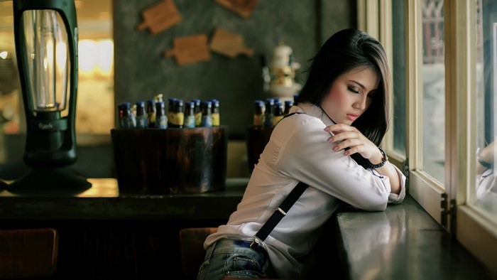 Woman in White Blouse Sitting by Window