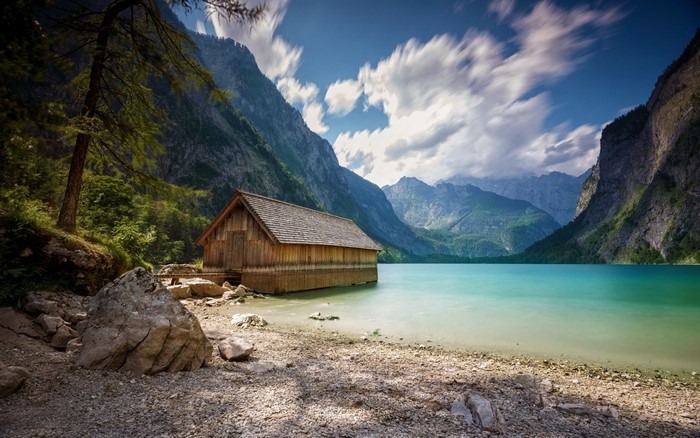 Wooden boathouse on a turquoise lake with mountains