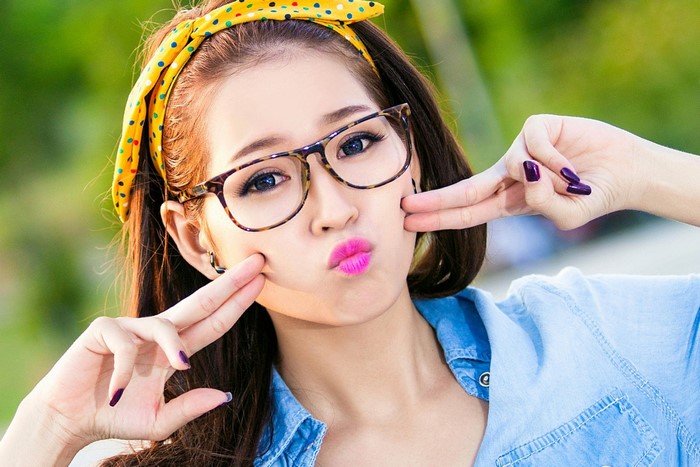 Young Asian woman wearing glasses and yellow polka dot headband