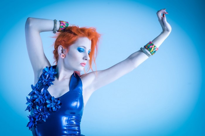 Woman with orange hair in blue latex costume
