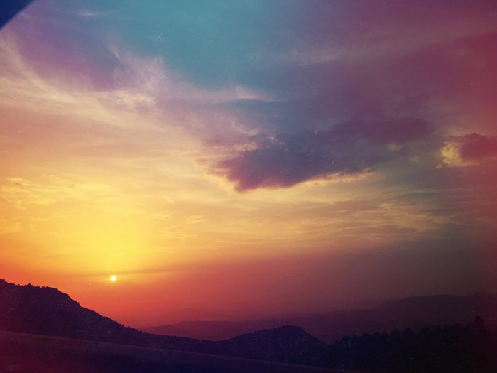 Sunset over mountains with colorful clouds