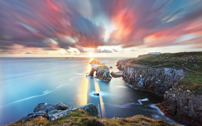 Sunset Over Rocky Coastal Cliffs and Calm Sea