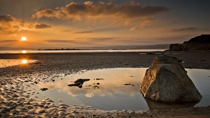 Sunset over a rocky beach with tide pools