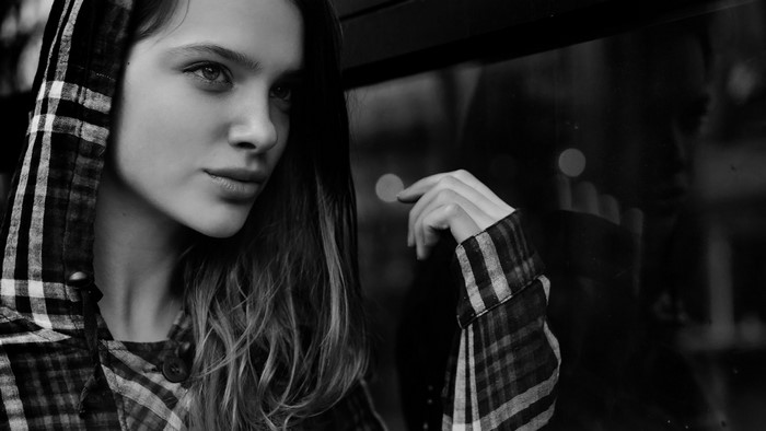 Monochrome portrait of a young woman in a hooded plaid shirt