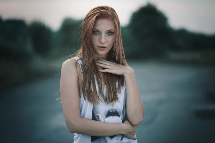 Redhead woman with hand on neck in portrait