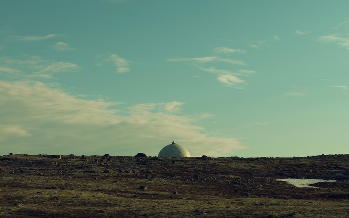 Dome building on a rocky hill under a cloudy sky