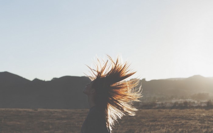 Woman with hair blowing in the wind at sunset
