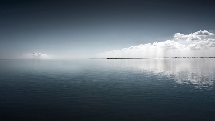 Calm sea under a cloudy sky with distant horizon