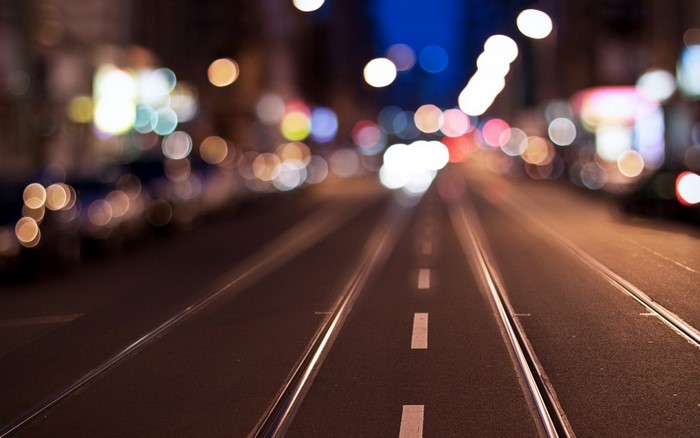 Bokeh lights on a city street at night with tram tracks