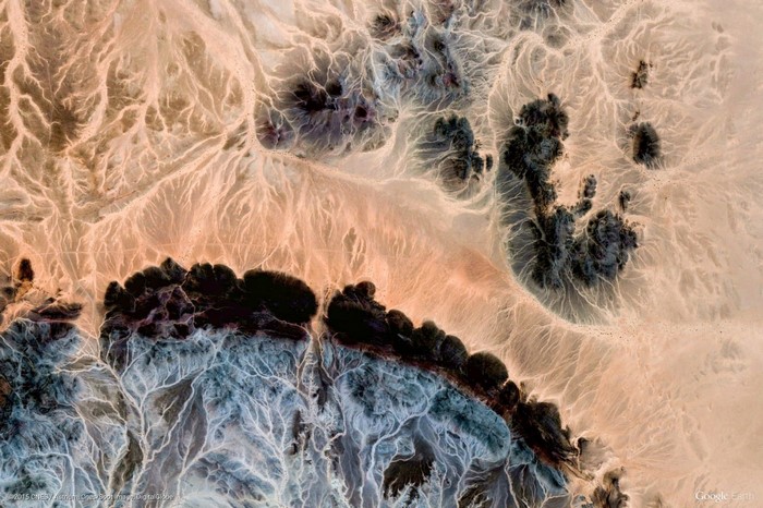 Aerial view of desert landscape with dark formations