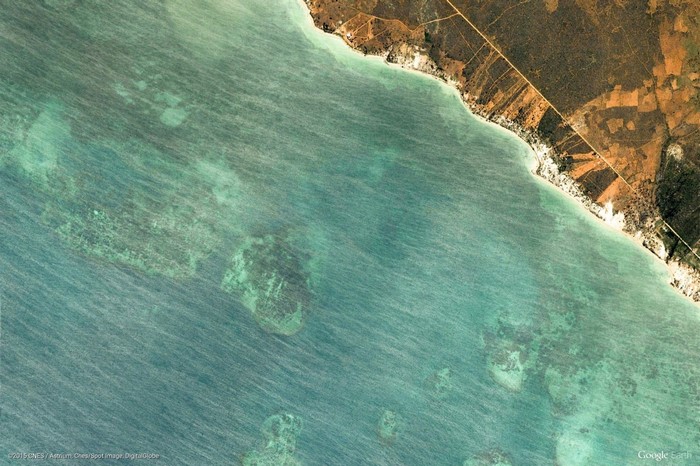 Aerial view of a coastline with turquoise water and coral reefs