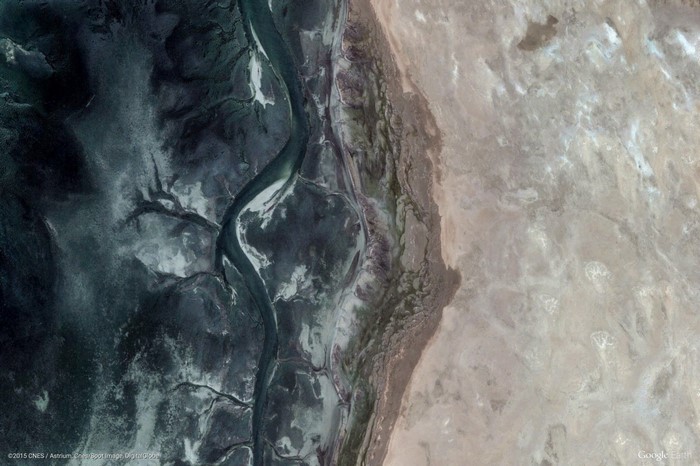 Aerial view of a river delta and desert terrain