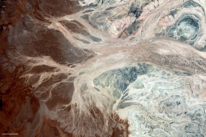 Aerial view of arid geological formations and dry riverbeds