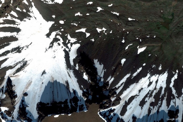 Snowy mountain landscape with dark rocky terrain