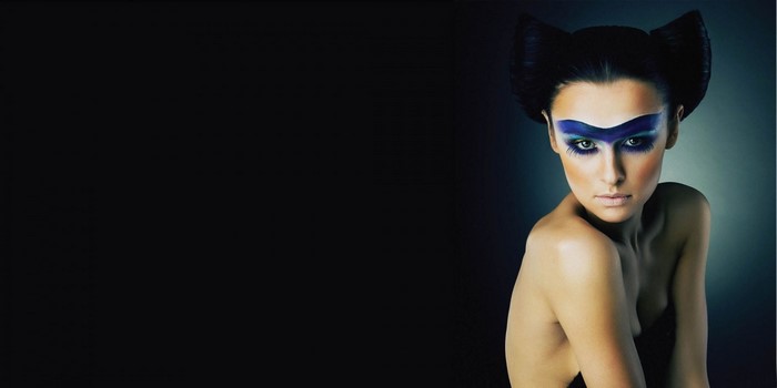 Woman with dramatic blue eye makeup and cat ears hairstyle