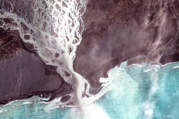 Aerial view of a braided river delta meeting the sea
