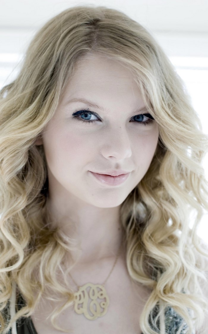 Taylor Swift portrait with blonde wavy hair and necklace